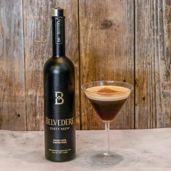 Belvedere Dirty Brew organic coffee flavored vodka bottle next to a martini glass with a coffee cocktail.