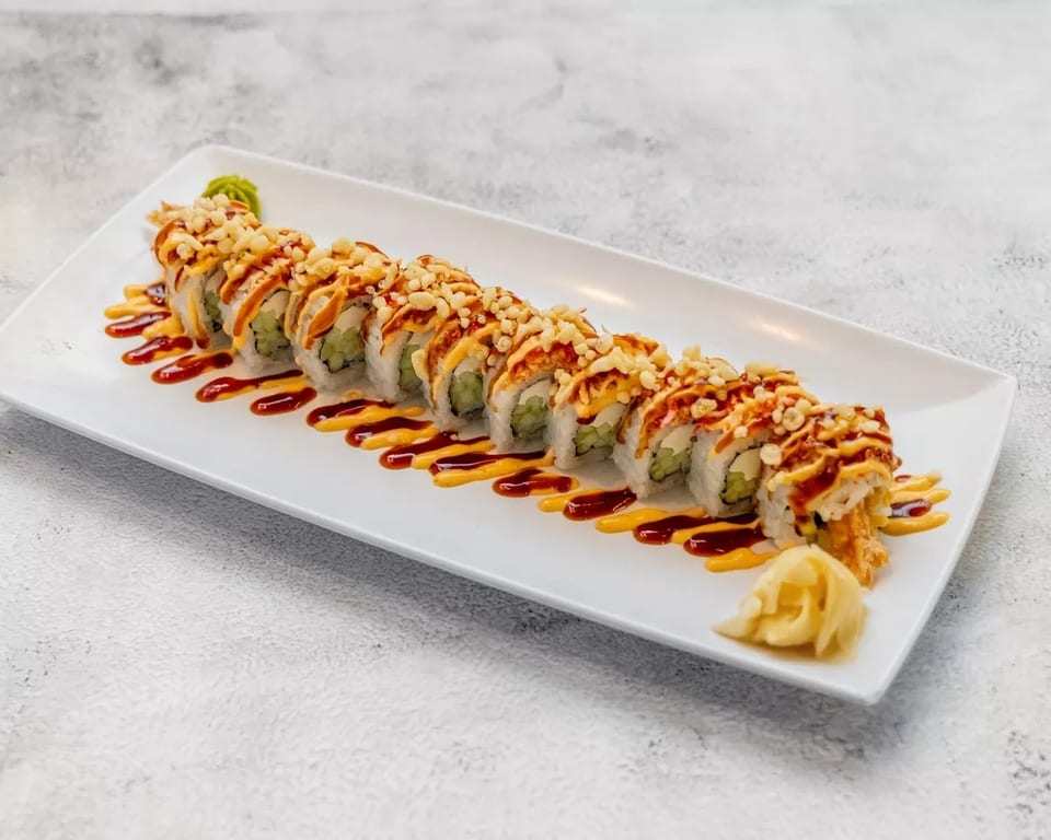 Sushi roll with crispy toppings and two sauces, served with ginger and wasabi.
