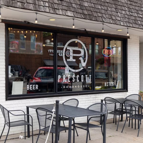 Prescott Roadhouse exterior with outdoor seating, large windows, and an "OPEN" sign.