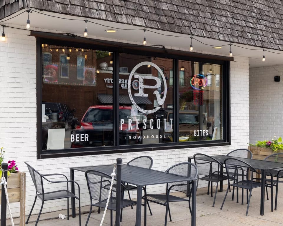 Prescott Roadhouse exterior with outdoor seating, large windows, and an "OPEN" sign.